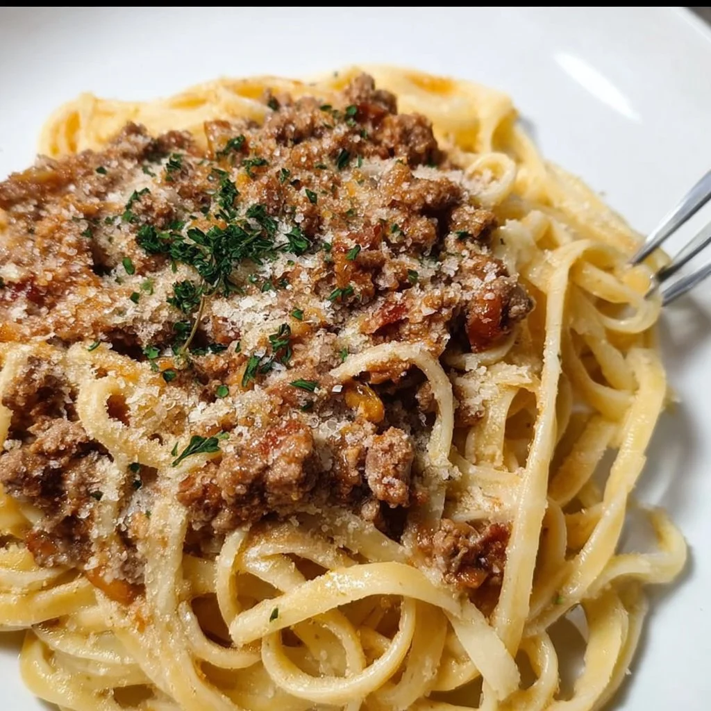 Delicious White Ragù sauce served over pasta with herbs and vegetables