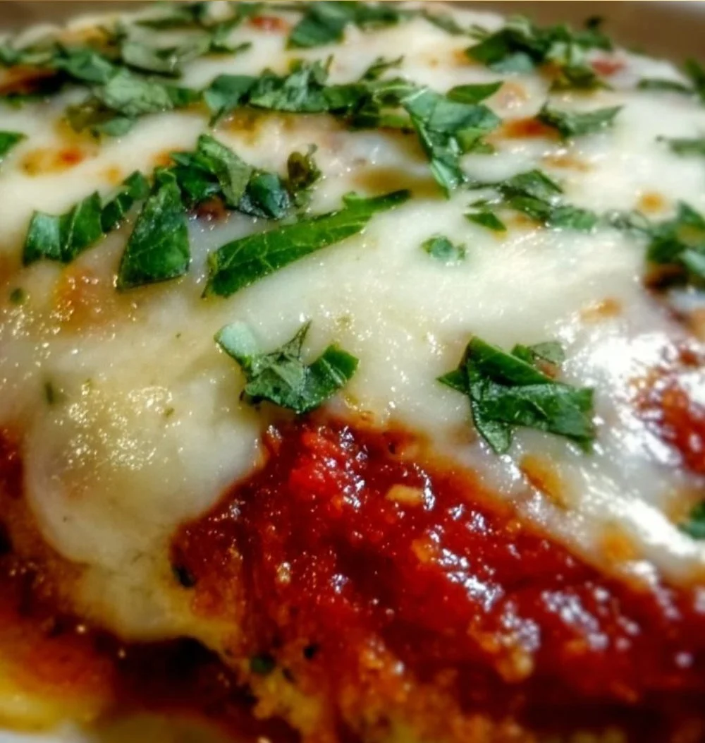 Bobby Flay's delicious Chicken Parmesan served with pasta and garnished with herbs