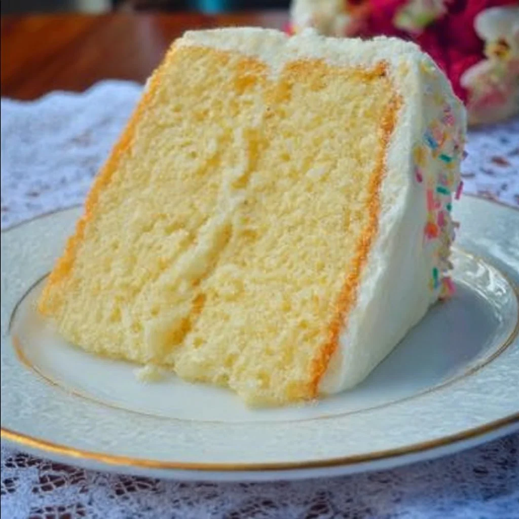 Slice of Vanilla Dream Cake decorated with fresh berries and cream