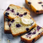 Delicious blueberry lemon quick bread sliced on a wooden board